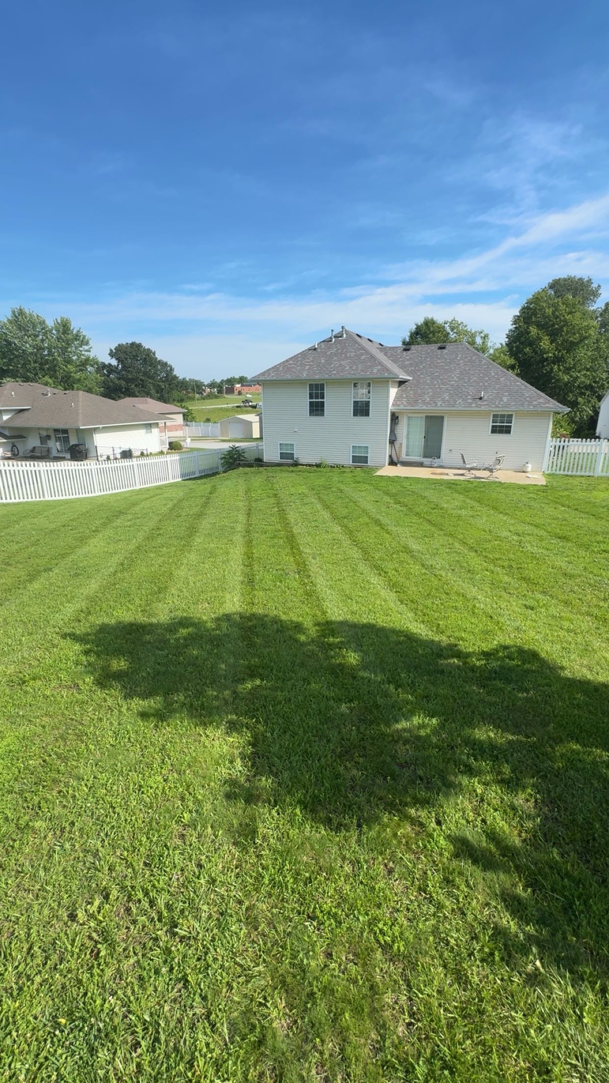 A Jefferson City, MO backyard with crisp, freshly mowed stripes - real Rademan Lawncare and Landscaping work